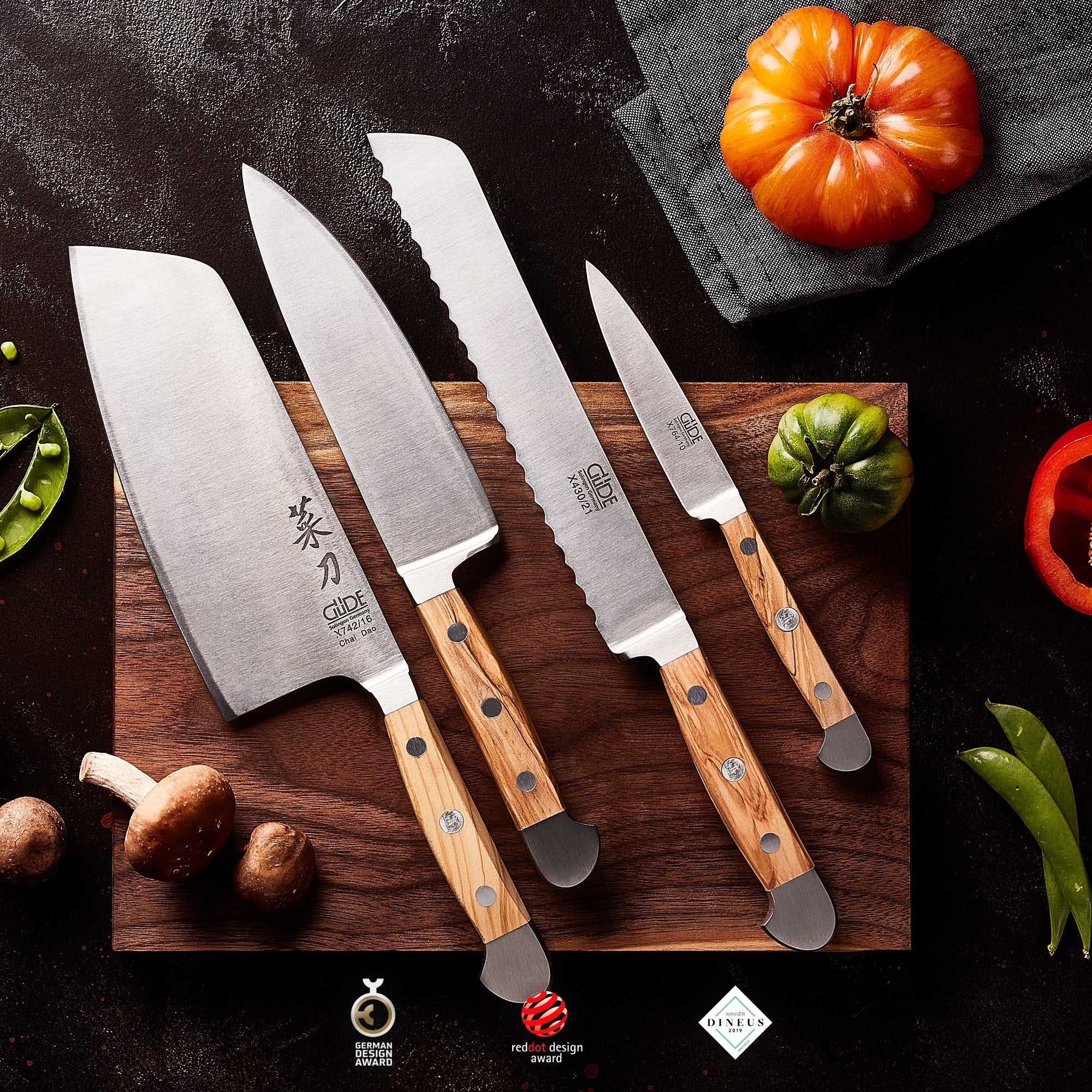 GÜDE Knives Solingen Germany displayed on a wooden cutting board with vegetables.