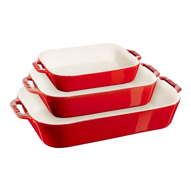 Set of three red ceramic baking dishes on a white background