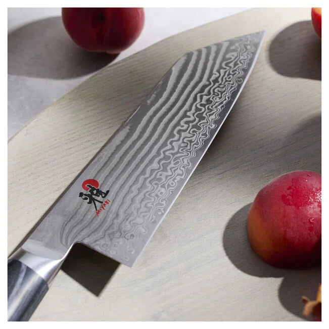 Miyabi Kaizen II 5000FCD 7-inch Bunka knife with stunning Damascus steel design and fresh fruits.