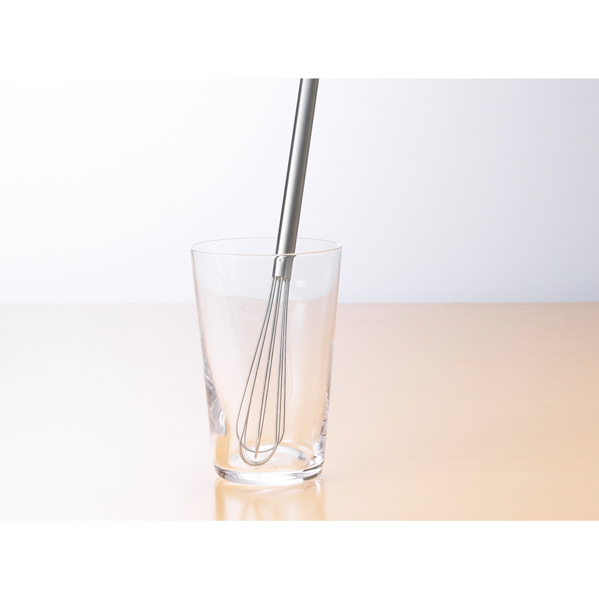 Eatoco Stainless Steel Whisk stirring in a glass, showcasing its elegant design and efficient mixing capability.
