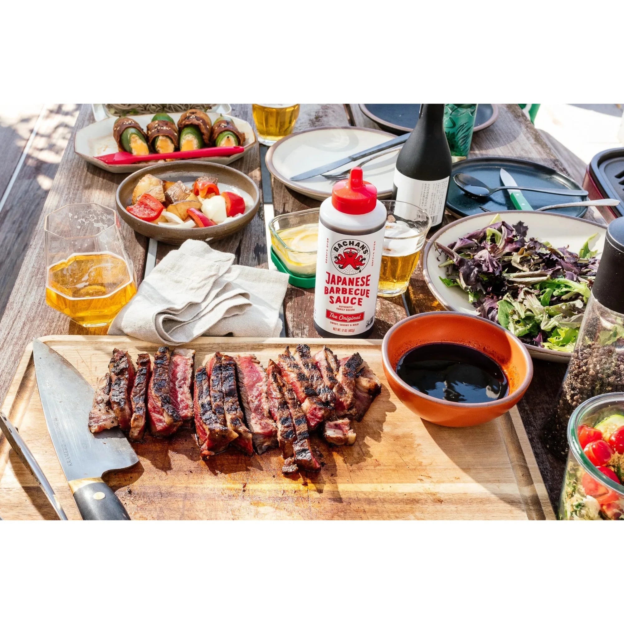 Bachan’s Original Japanese Barbecue Sauce displayed on a dining table with grilled meat and various side dishes.