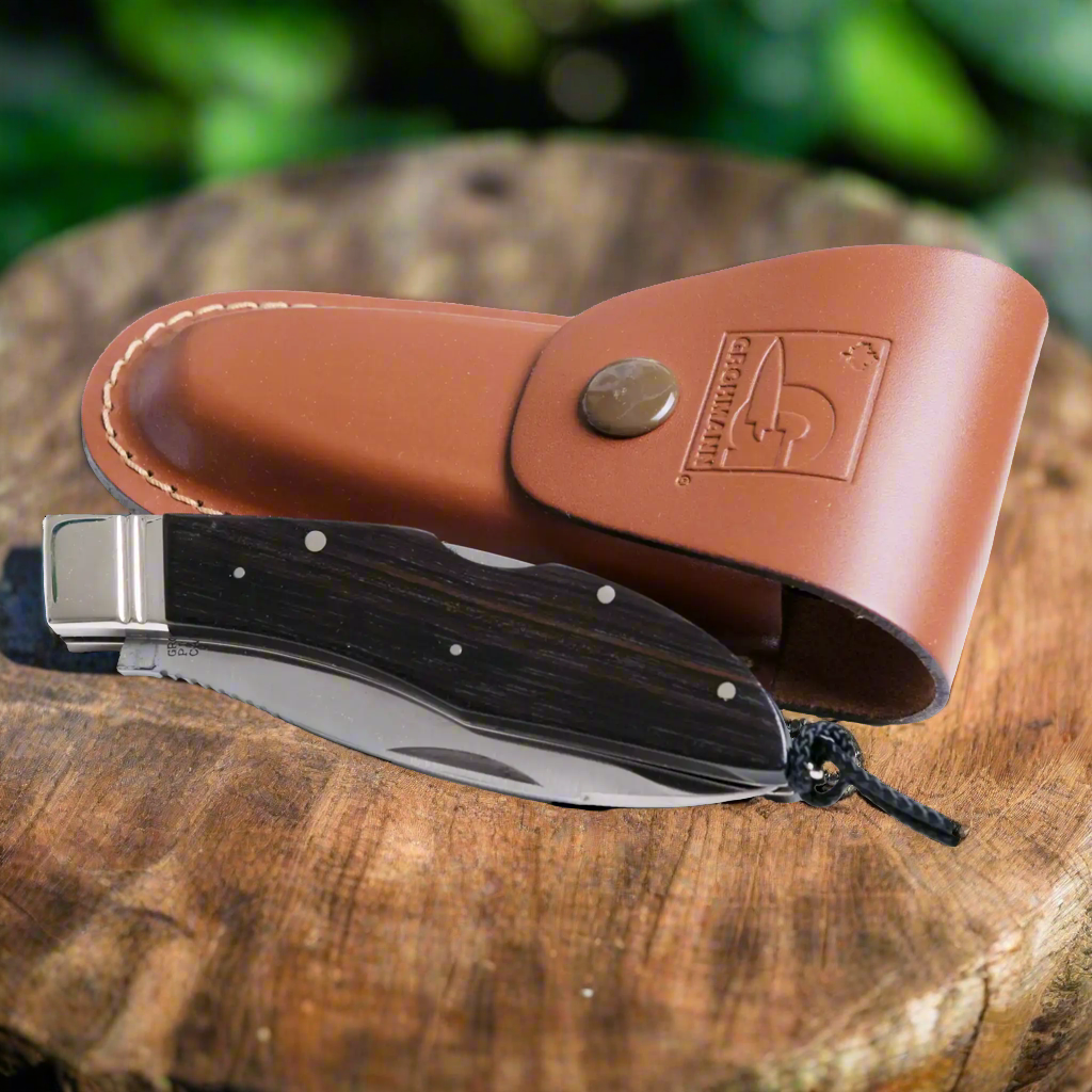 Grohmann D.H. Russell Canadian Belt Knife – 65th Anniversary Edition (Black/Gold) Hunting Knives on top of wood log