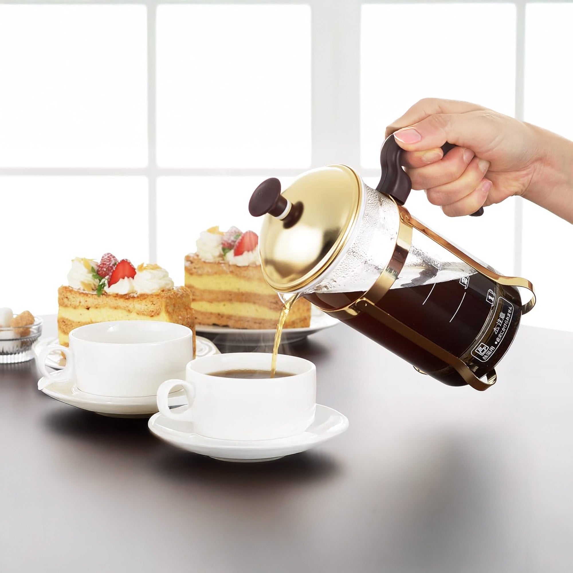 Pouring coffee from Yoshikawa Stainless Steel Coffee Press Server 600ml – Made in Japan, with desserts in the background.