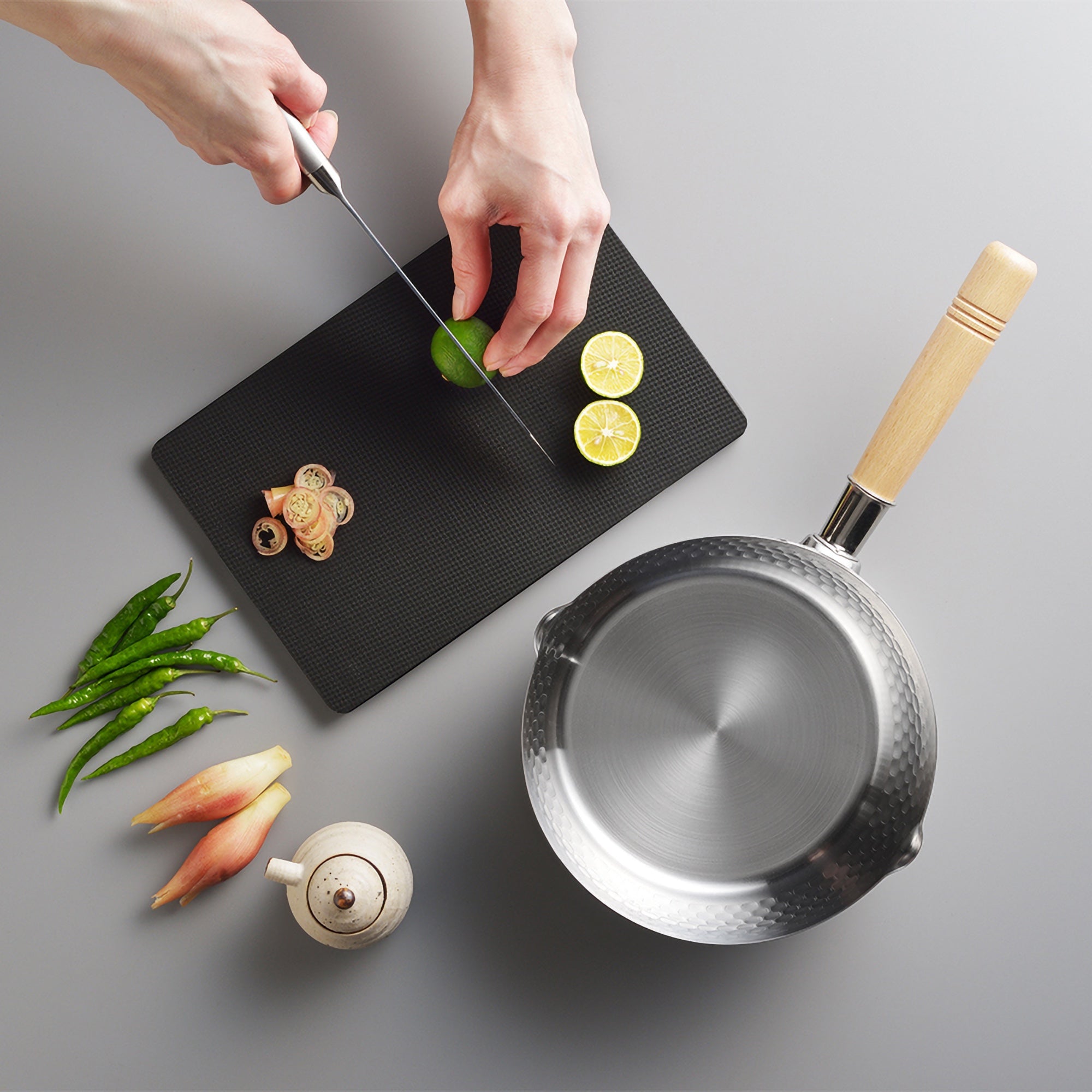 man cutting veggies on top of cutting board beside Yoshikawa Yukihira Saucepan