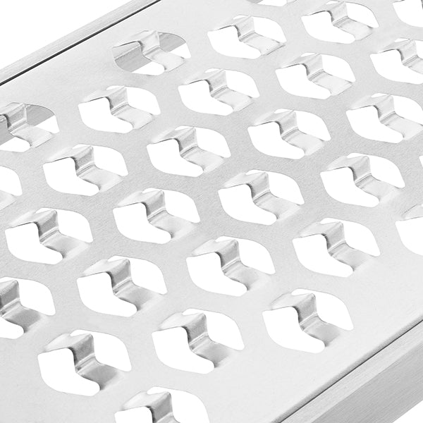 Close-up of a brushed silver metal surface with a repeating pattern of oval cutouts showing white background through the holes.